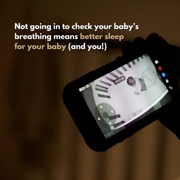 A hand holds a baby monitor showing a sleeping baby in Breathing Reassurance Convertible Baby PJ's, with text above: Not going in to check your baby's breathing means better sleep for your baby (and you!).