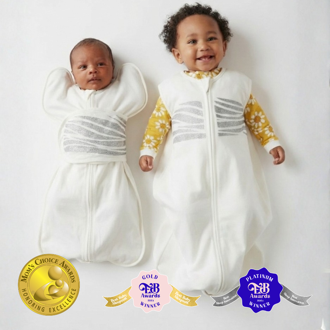 Newborn baby in a Sleep of Mind swaddle and a 5 month old baby in a Sleep of Mind sleep sack, both laying on a white surface side by side
