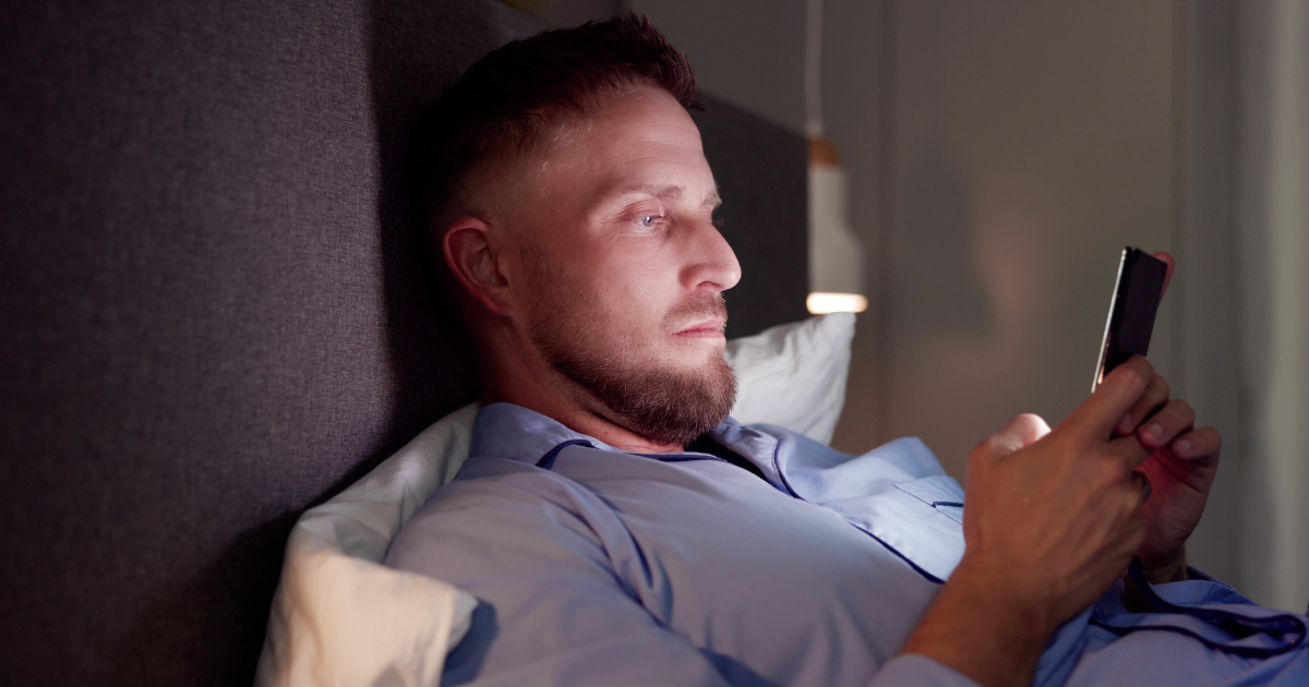 A worried parent awake at night, watching the baby monitor