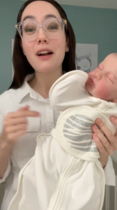 Woman holding a baby wrapped in a Sleep of Mind swaddle