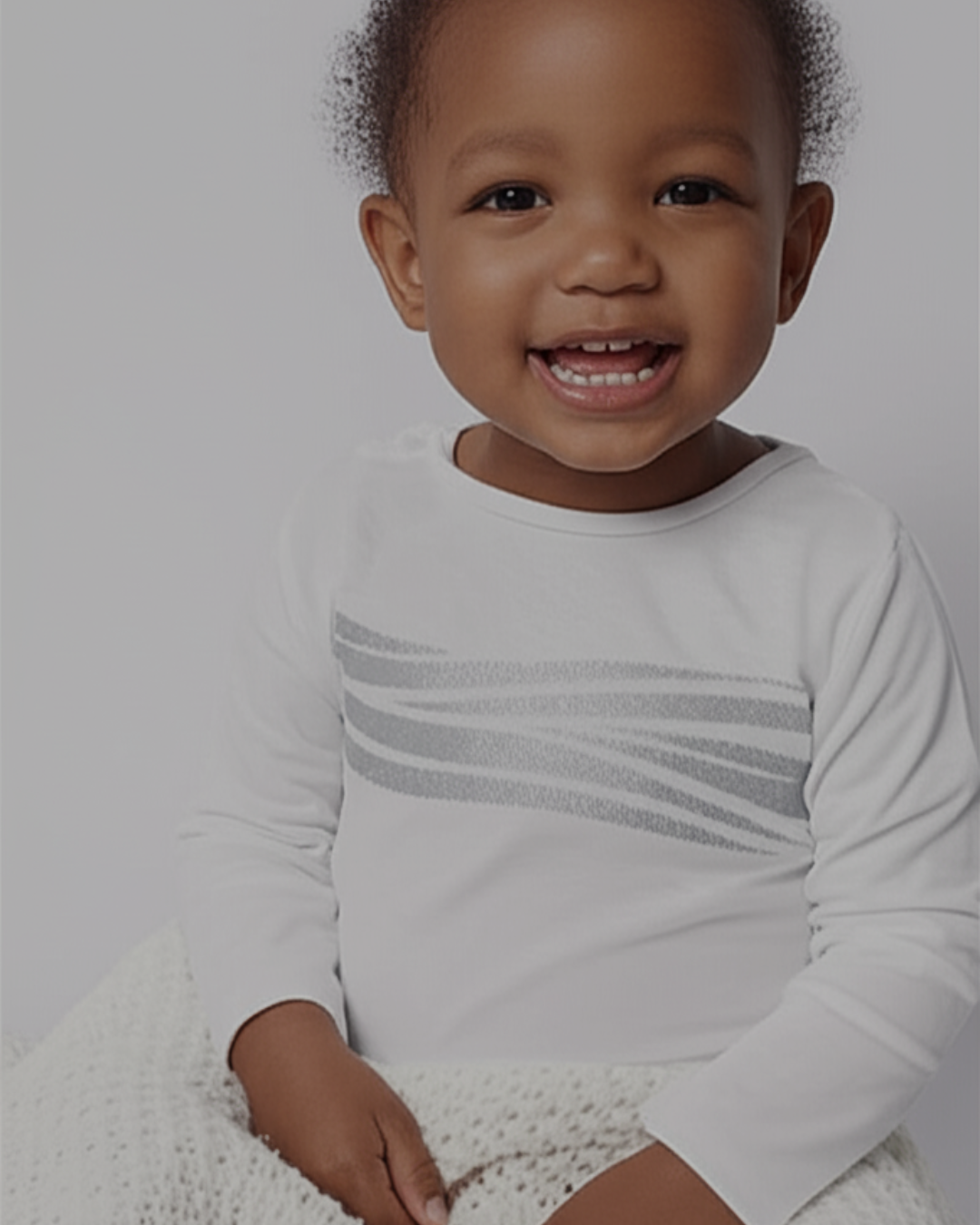 Toddler wearing a white Sleep of Mind pajama top 